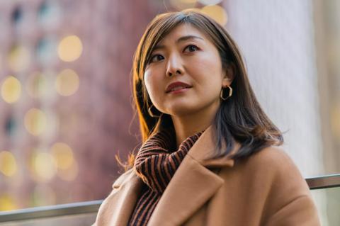 A portrait of a businesswoman at night in downtown district.